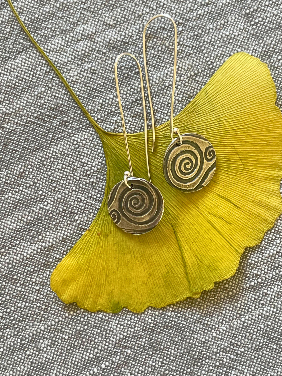 Link to PMC page - a pair of earrings with a spiral design on them, made of precious metal clay